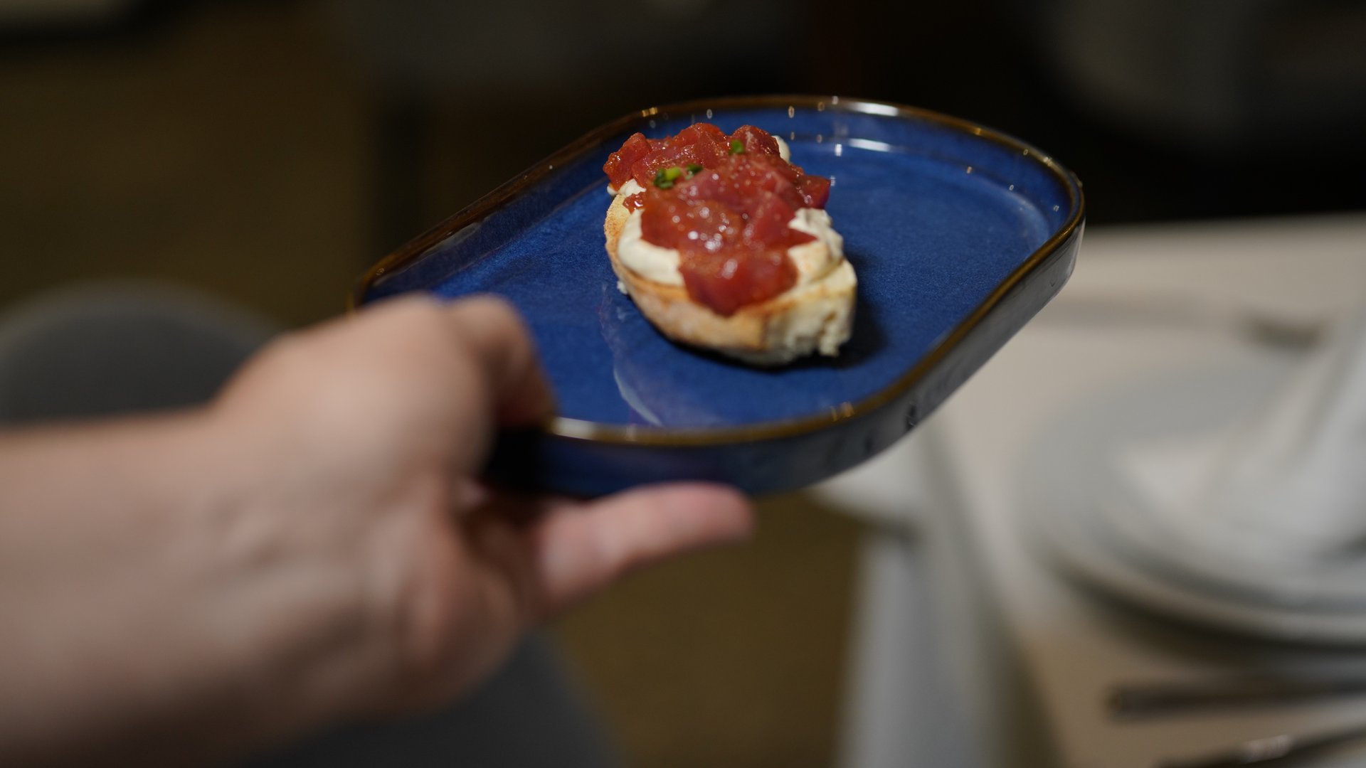 Tosta de atún rojo sobre plato azul artesanal